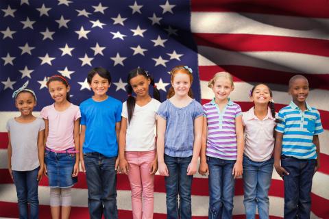 Young Americans Cute kids with American flag in background